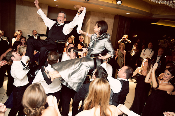 parents of the newlywed being carried around during reception - photo by Houston based wedding photographer Adam Nyholt